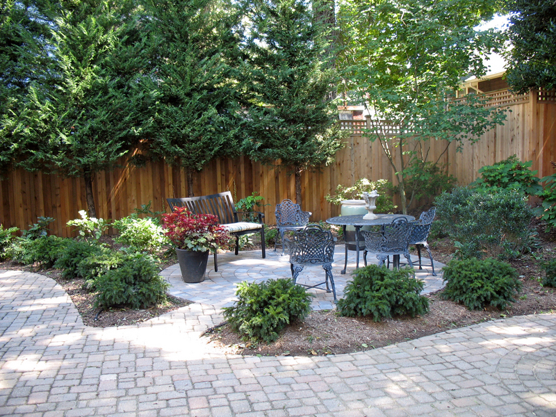 A round patio with surrounding plantings was created in what used to be a lawn to add entertaining space and a more attractive view from the house.